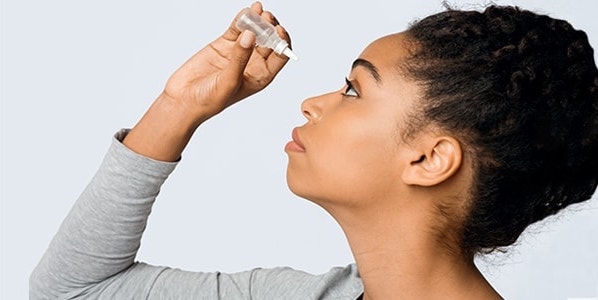 Patient putting in glaucoma eye drops to reduce glaucoma eye pressure and glaucoma symptoms.
