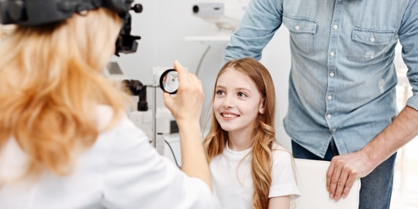 Pediatric eye specialist examining child's eyes for childhood eye disorders.